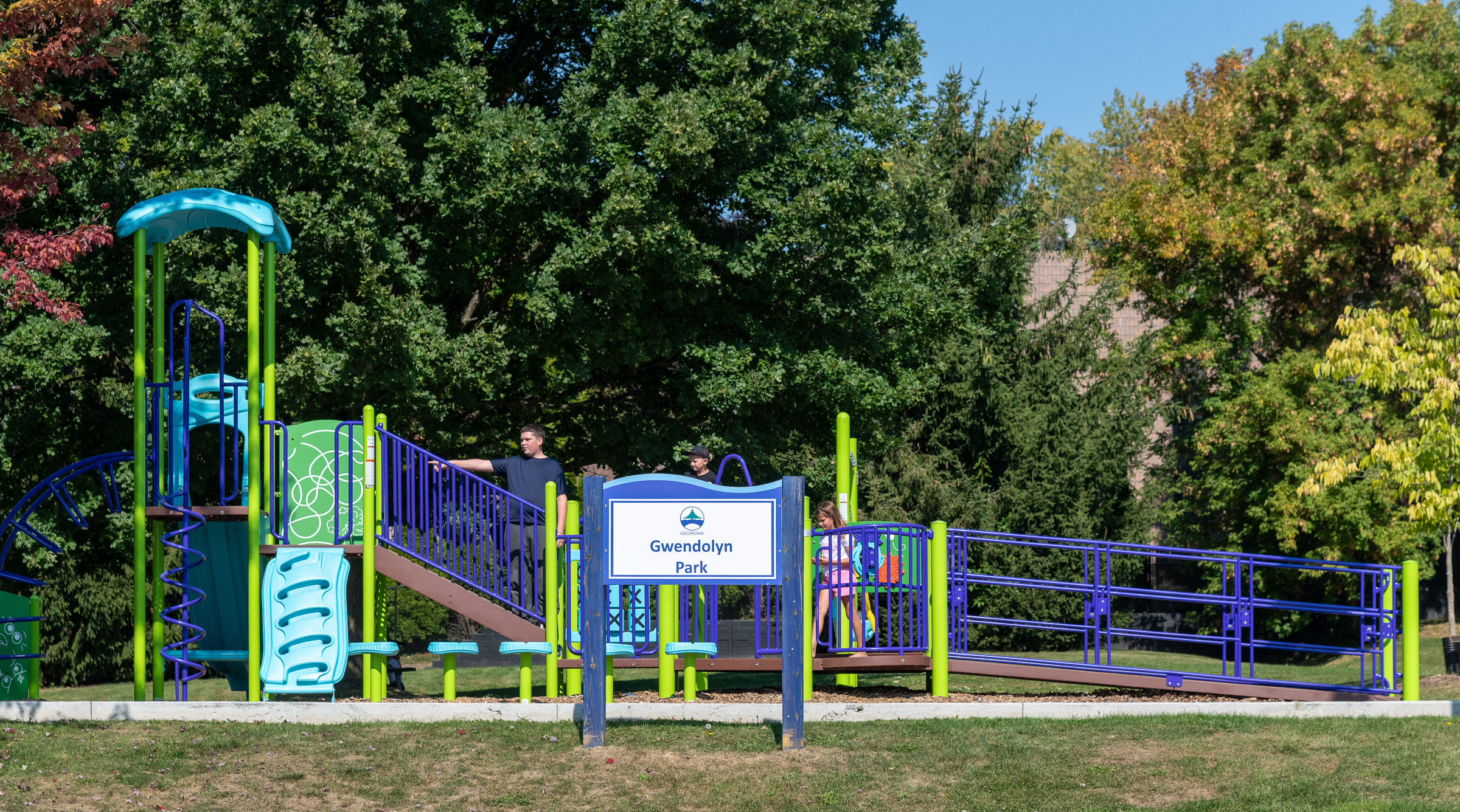 children playing on a purple and green play structure