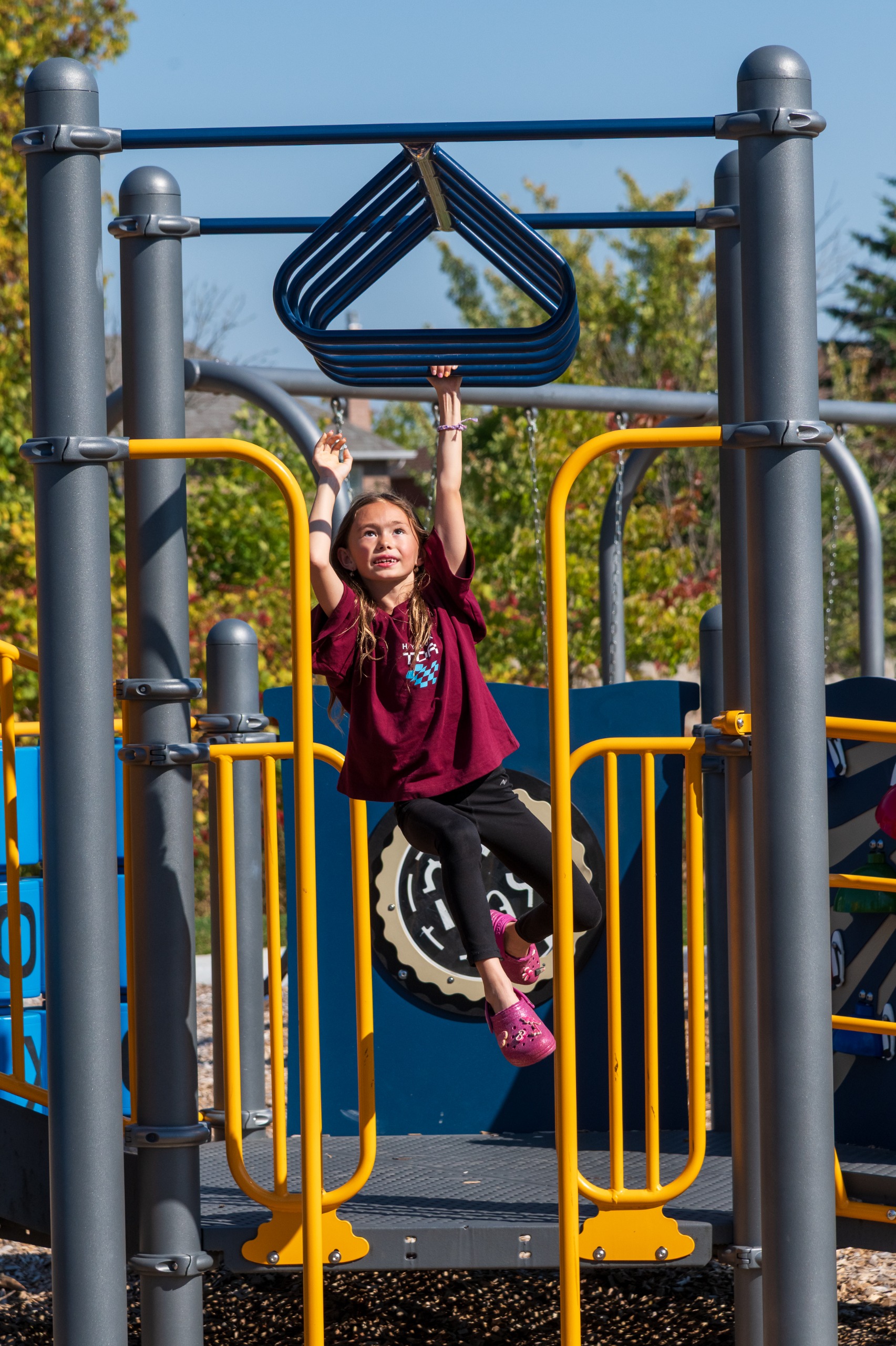 Child on monkey bars on play structure