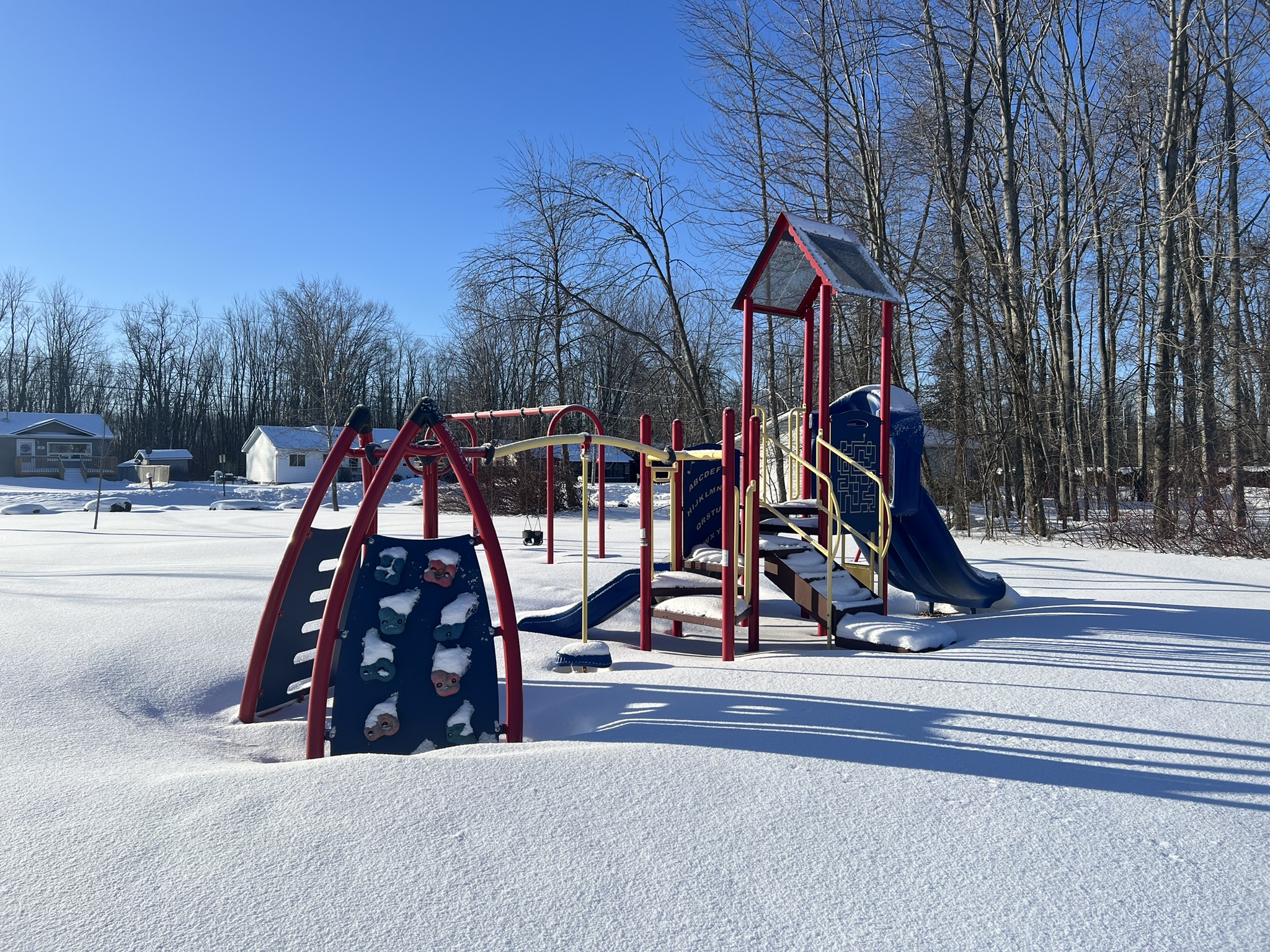 An outdoor playground with snow on the ground.