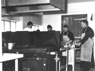 Black and white photo of five people working in the Novitiate kitchen.