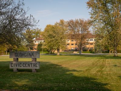Exterior of the old Civic Centre with a wooden sign in front. 2022.