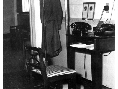 Black and white photo of a phone and desk.